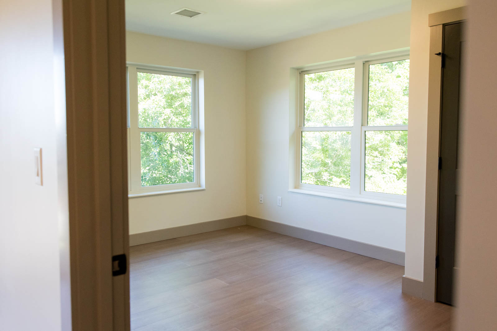Bedroom at Brook Hill with large windows and wood-look flooring
